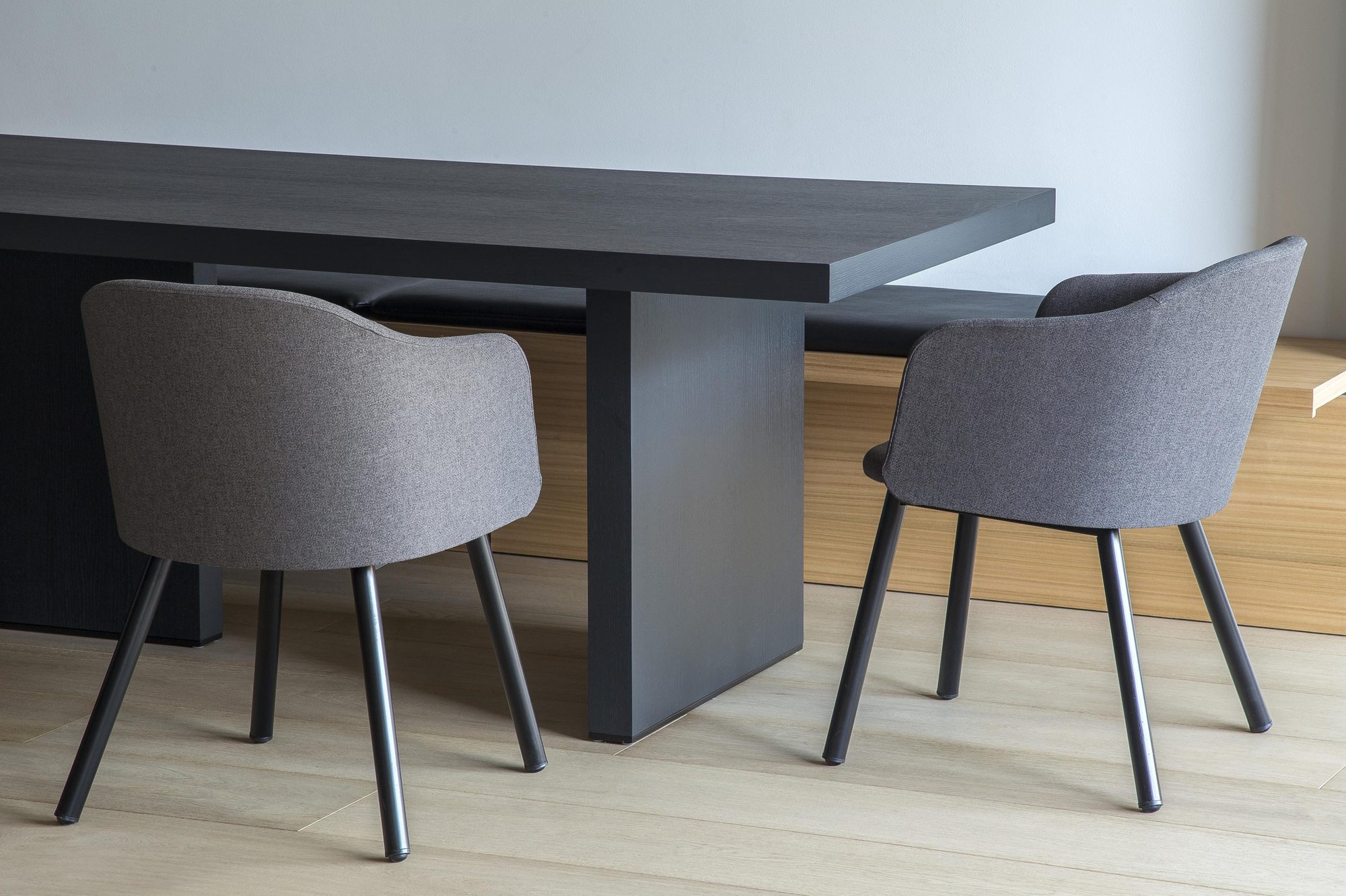 Cadeiras BE WOOD tapizadas junto a uma mesa de reunião escura