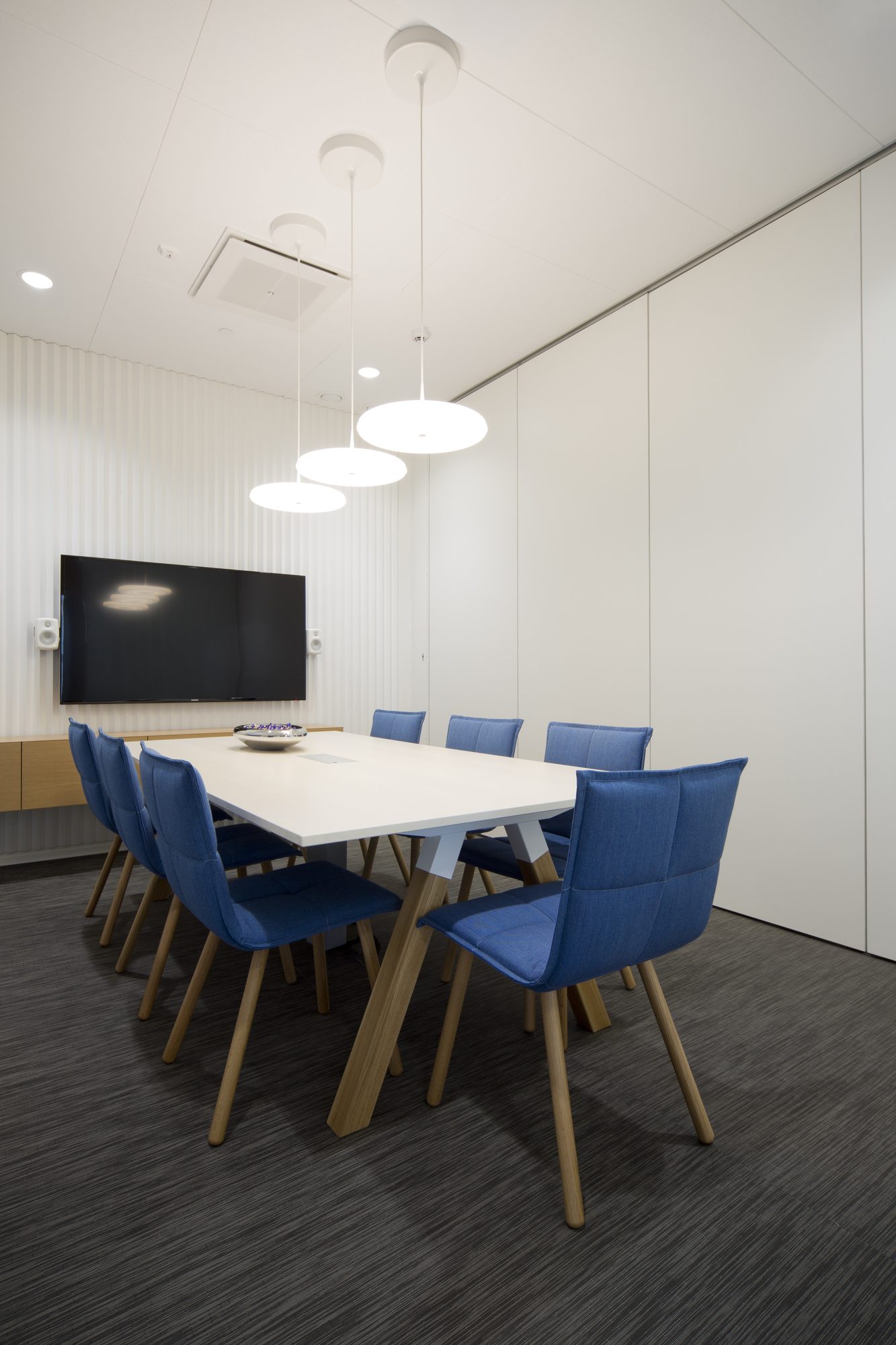Sala de reuniões com cadeiras Lab Meeting azuis em torno de uma mesa branca