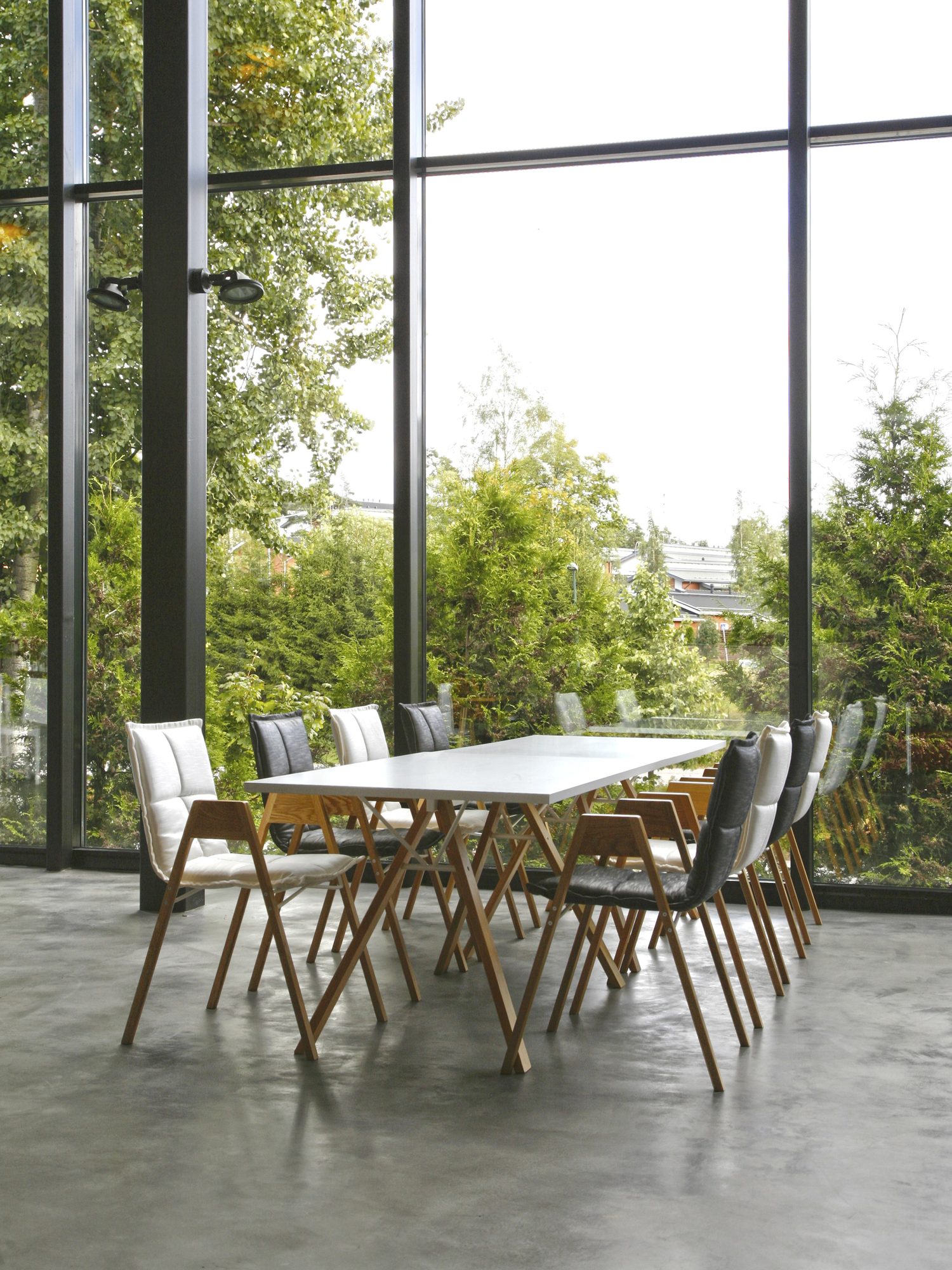 Cadeiras Lab W numa sala envidraçada com vista para árvores