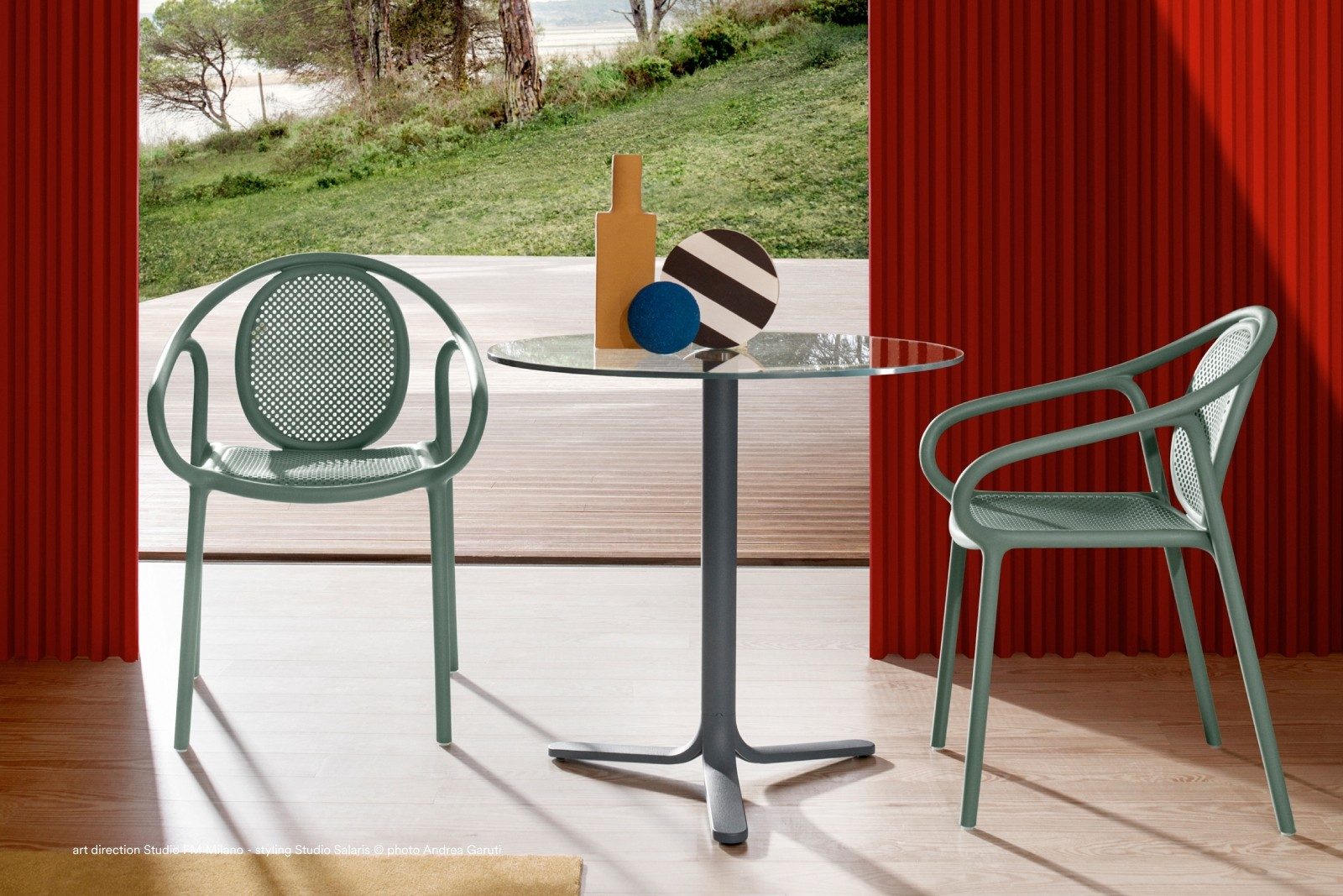 Poltronas Remind e mesa de vidro num jardim